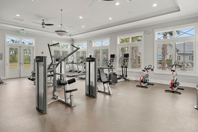 gym with a healthy amount of sunlight, french doors, a tray ceiling, and ornamental molding