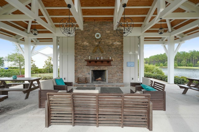 view of patio / terrace featuring a water view, a gazebo, and an outdoor living space with a fireplace