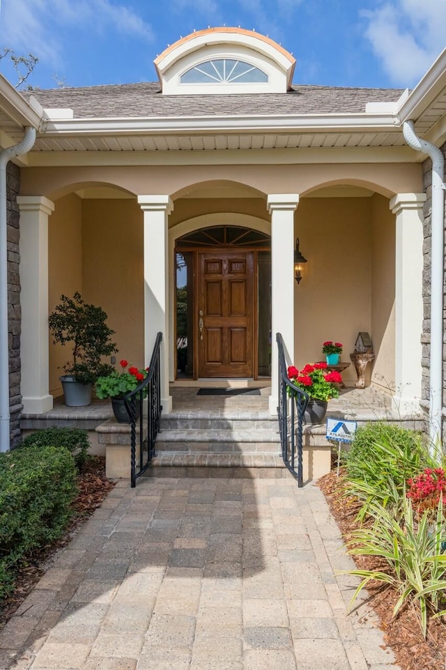 485 Ocean Forest Dr, Saint Augustine, FL 32080 - property entrance featuring covered porch, stone siding, stucco siding, and roof with shingles