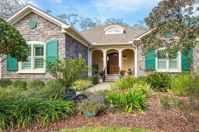 485 Ocean Forest Dr, Saint Augustine, FL 32080 - view of front of home featuring stone siding, a porch, and roof with shingles