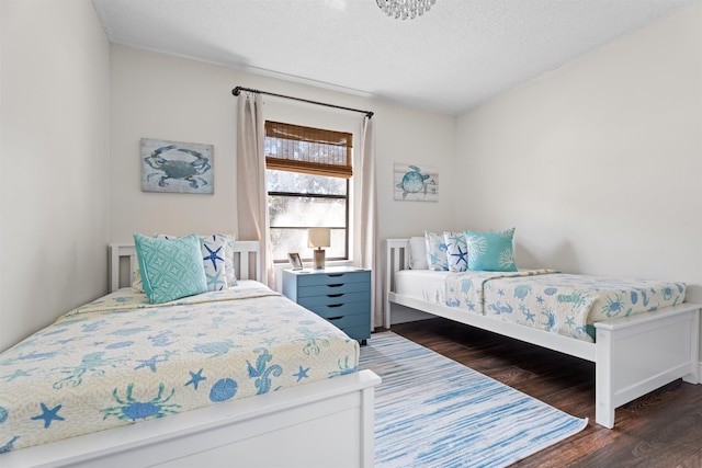 bedroom featuring wood finished floors and a textured ceiling