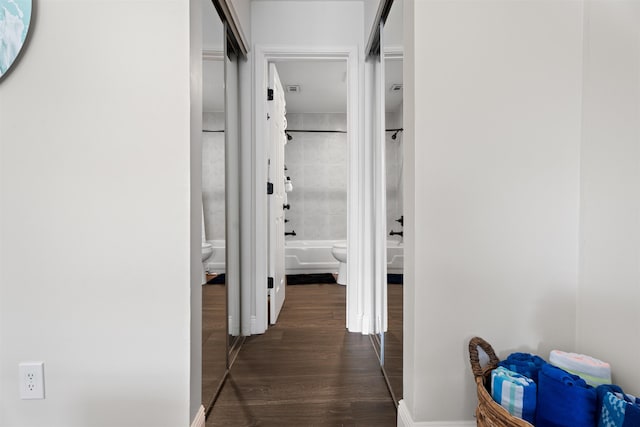 hallway with dark wood-style floors and baseboards