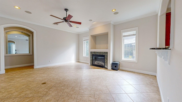 unfurnished living room with crown molding, light tile patterned floors, and ceiling fan