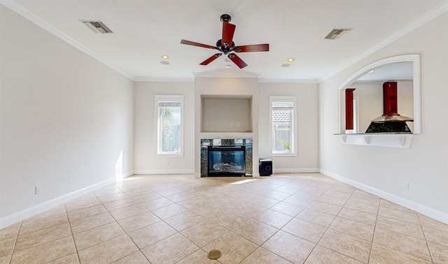 unfurnished living room with crown molding, light tile patterned floors, and a healthy amount of sunlight