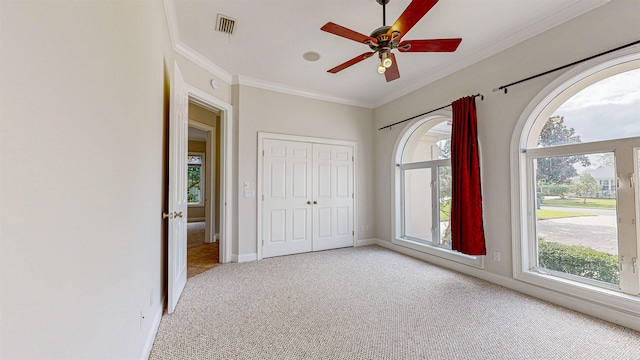 unfurnished bedroom with multiple windows, ceiling fan, and light colored carpet