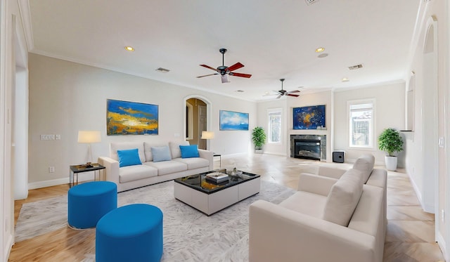 living room with a high end fireplace, light hardwood / wood-style flooring, and ornamental molding