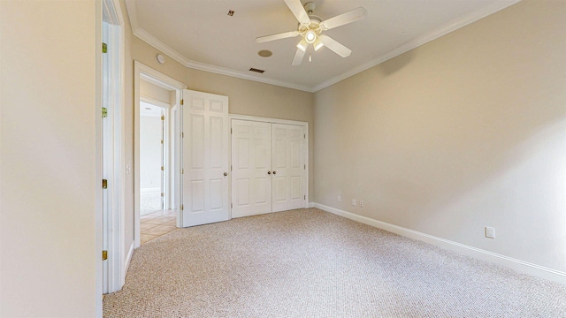 unfurnished bedroom with ceiling fan, a closet, light carpet, and ornamental molding