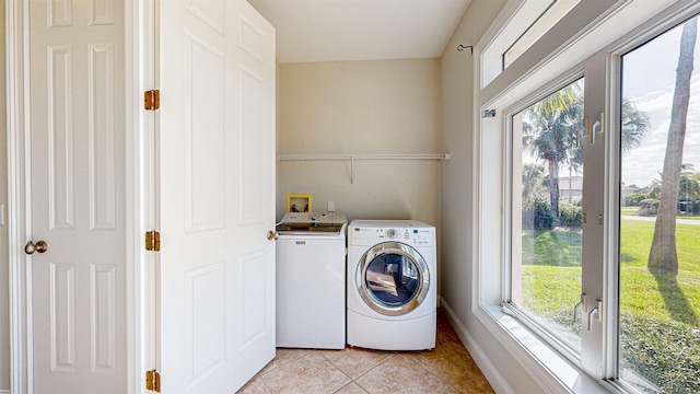 washroom with light tile patterned floors and washer and clothes dryer