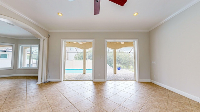 tiled empty room with ornamental molding, ceiling fan, and a healthy amount of sunlight