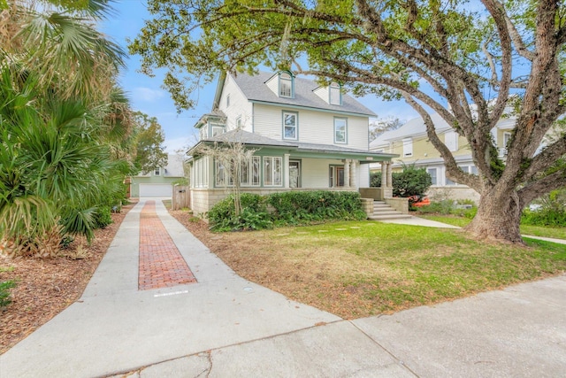 view of front of house featuring a front yard, driveway, roof with shingles, covered porch, and a garage