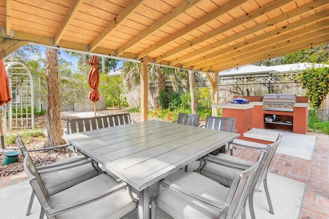 view of patio with grilling area, outdoor dining area, and a fenced backyard