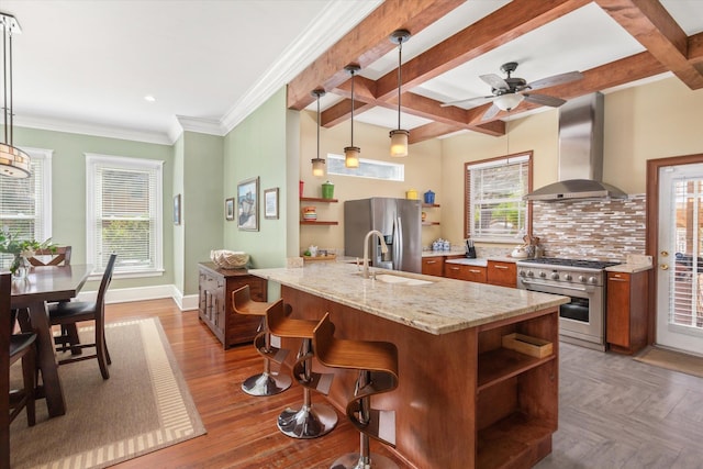 kitchen featuring open shelves, a sink, tasteful backsplash, stainless steel appliances, and wall chimney range hood