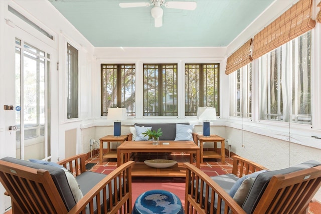 sunroom / solarium featuring a ceiling fan