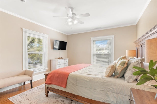 bedroom featuring multiple windows, ceiling fan, ornamental molding, and wood finished floors