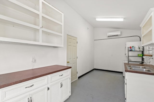 kitchen with finished concrete flooring, lofted ceiling, open shelves, a wall mounted air conditioner, and dark countertops