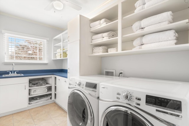 laundry area with light tile patterned flooring, cabinet space, ornamental molding, a sink, and washer and clothes dryer