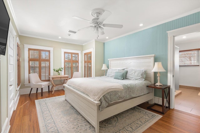 bedroom with baseboards, wood finished floors, and ornamental molding