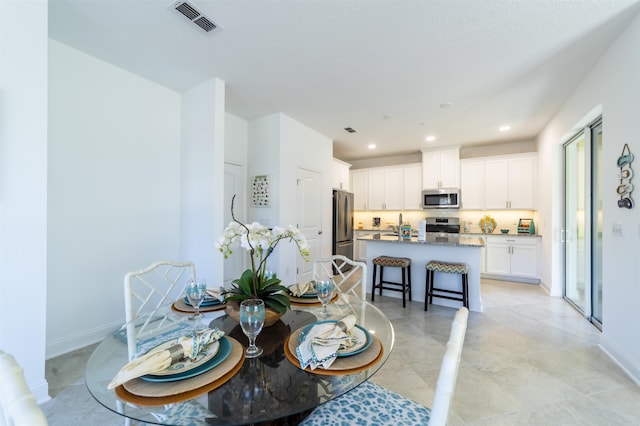 dining room with recessed lighting, visible vents, and baseboards
