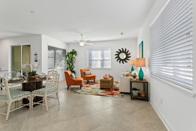 tiled living room with ceiling fan and baseboards