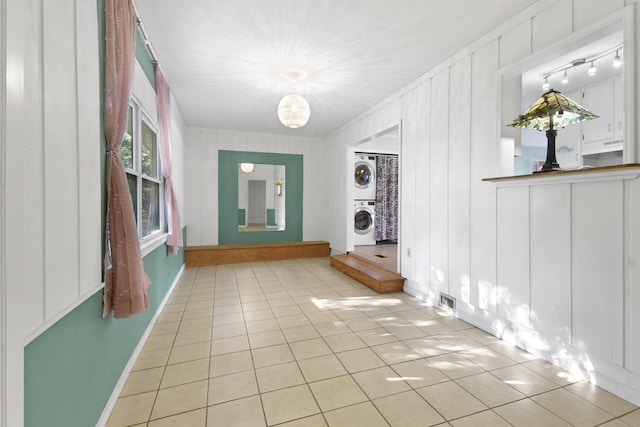 interior space featuring light tile patterned floors and stacked washer and dryer