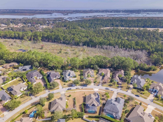 drone / aerial view with a water view, a forest view, and a residential view