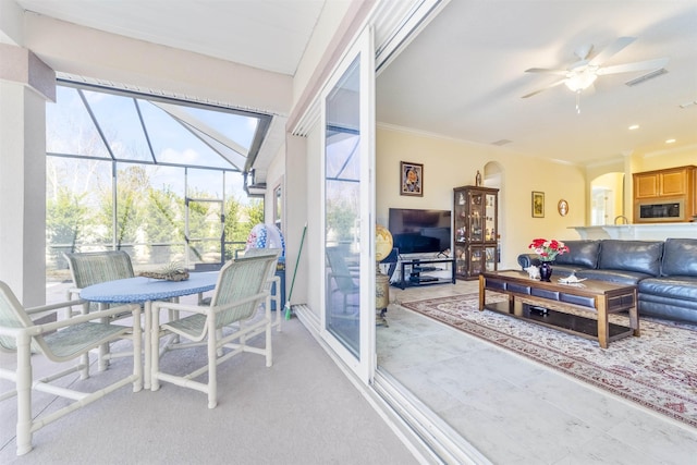 sunroom / solarium featuring plenty of natural light, visible vents, and ceiling fan