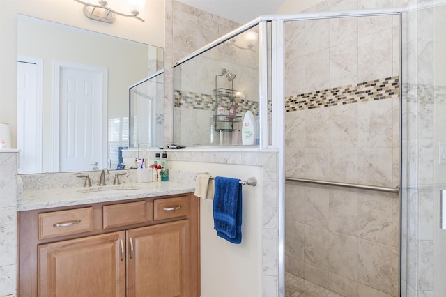 full bath with a stall shower and vanity