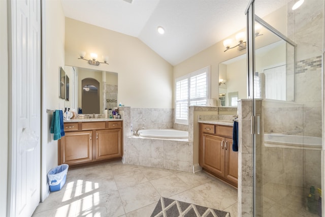 bathroom featuring lofted ceiling, a garden tub, vanity, a shower stall, and tile patterned floors