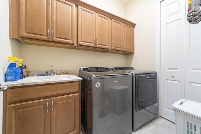 laundry area featuring washer and clothes dryer, a sink, and cabinet space