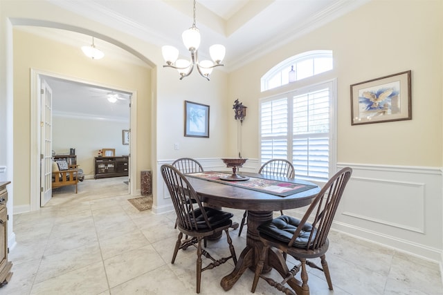 dining space featuring arched walkways, ornamental molding, wainscoting, and light tile patterned floors