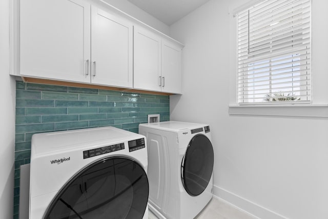 laundry area with cabinet space, washing machine and dryer, and baseboards