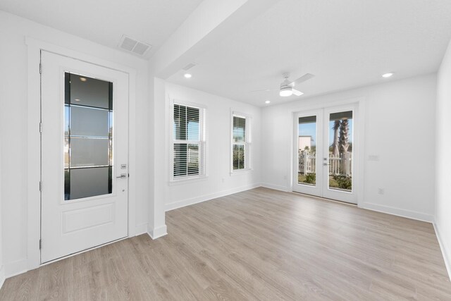 empty room featuring visible vents, french doors, light wood-type flooring, and baseboards