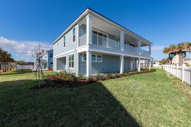 rear view of property featuring a lawn and fence