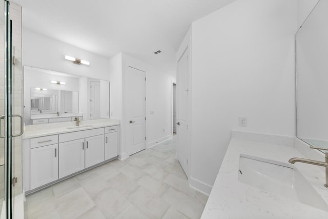 bathroom with two vanities, a stall shower, marble finish floor, and a sink