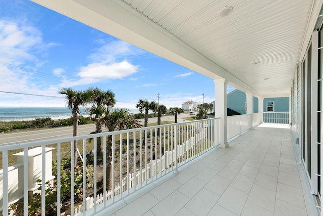 balcony featuring a beach view and a water view