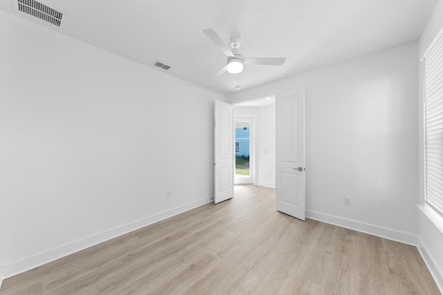 spare room featuring baseboards, visible vents, and light wood-type flooring