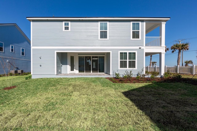 rear view of property with a lawn, central AC, and fence