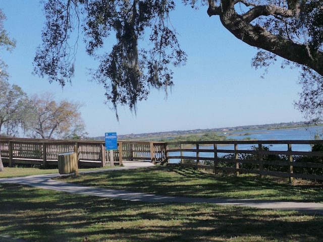 view of dock featuring a water view and a lawn