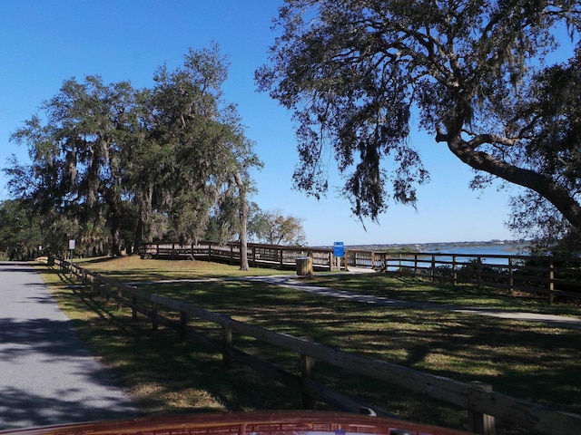 view of property's community featuring a lawn and a water view