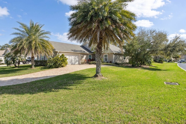 view of property hidden behind natural elements featuring a garage, decorative driveway, and a front yard