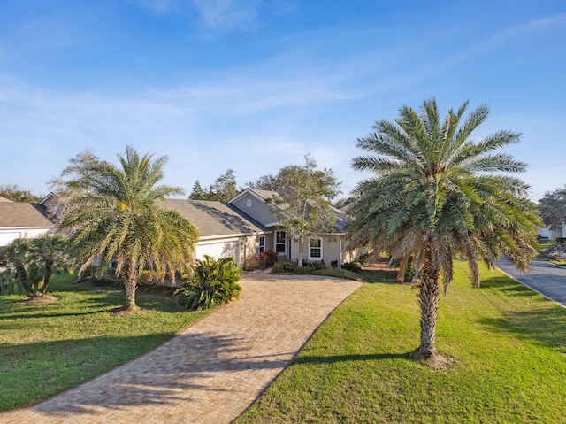 view of front facade featuring a garage, a front yard, and decorative driveway