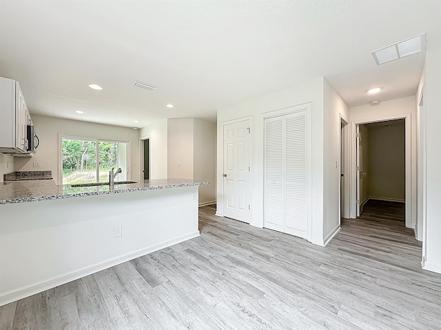 921 Helen St, Saint Augustine, FL 32084 - kitchen with a sink, light wood-type flooring, light stone countertops, a peninsula, and recessed lighting