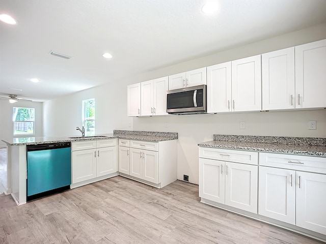 921 Helen St, Saint Augustine, FL 32084 - kitchen with dishwashing machine, stainless steel microwave, a sink, light stone countertops, and light wood-type flooring