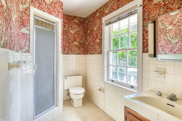 bathroom featuring an enclosed shower, vanity, tile patterned floors, and tile walls