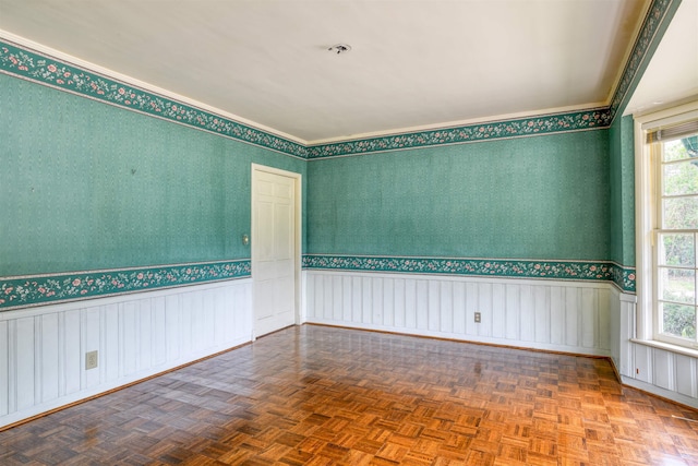 spare room featuring plenty of natural light, parquet floors, and crown molding