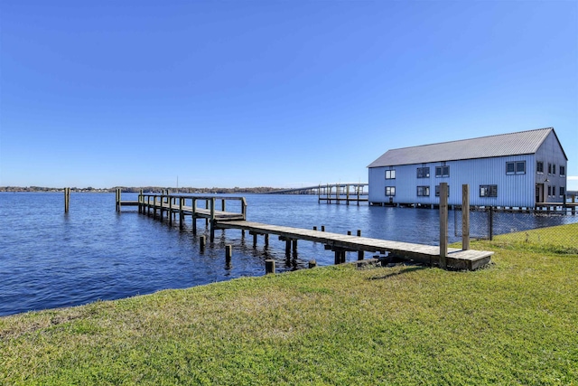 view of dock featuring a lawn and a water view