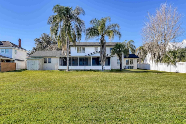 back of house with a lawn and a sunroom