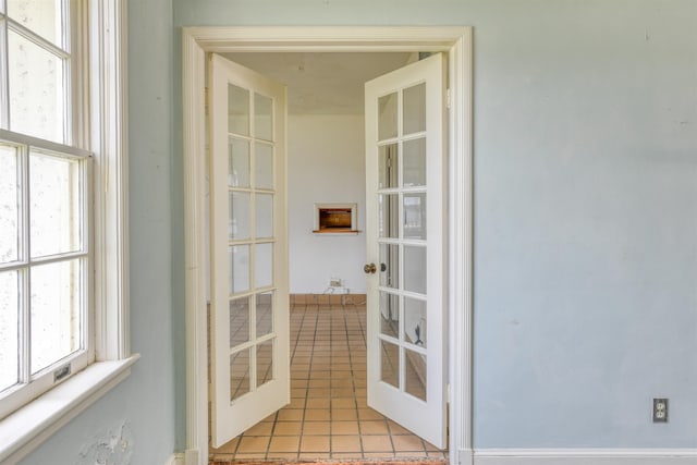 entryway with light tile patterned flooring and french doors