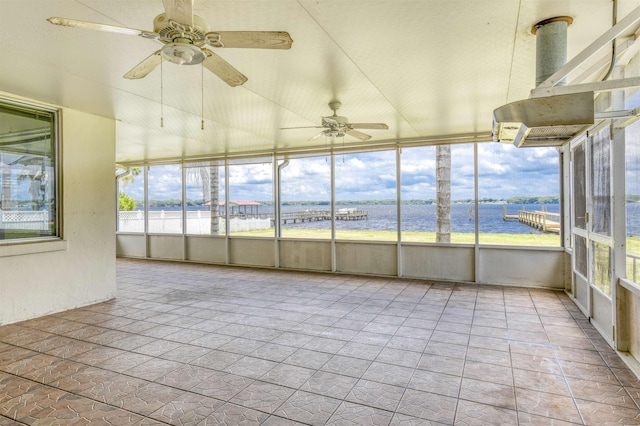 unfurnished sunroom featuring ceiling fan and a water view