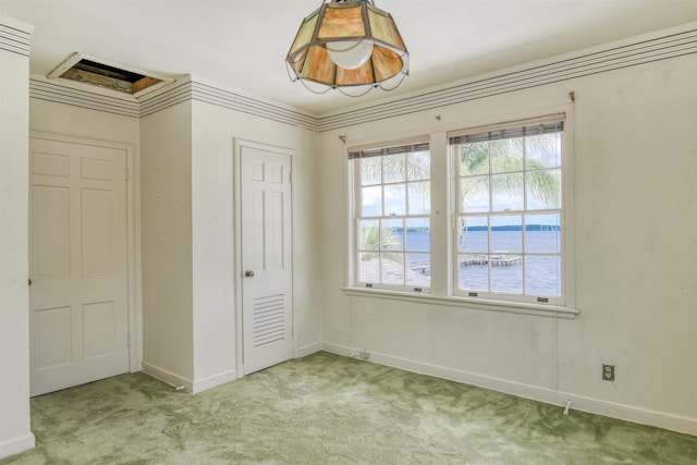 unfurnished bedroom with a water view, light colored carpet, and a closet